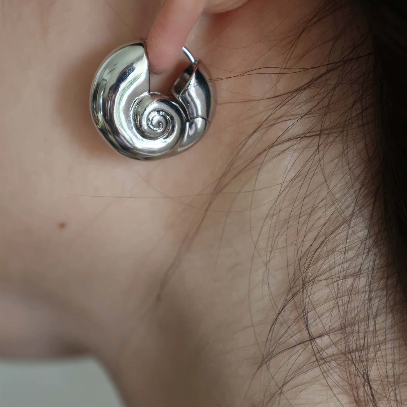 Boucle d’Oreille Coquillage Creuse en Cuivre sur une femme