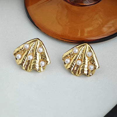 Boucle d’Oreille Coquillage Dorée à Perles sur fond gris et orange