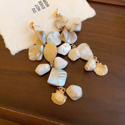 Boucle d’Oreille Coquillage Longue sur une table